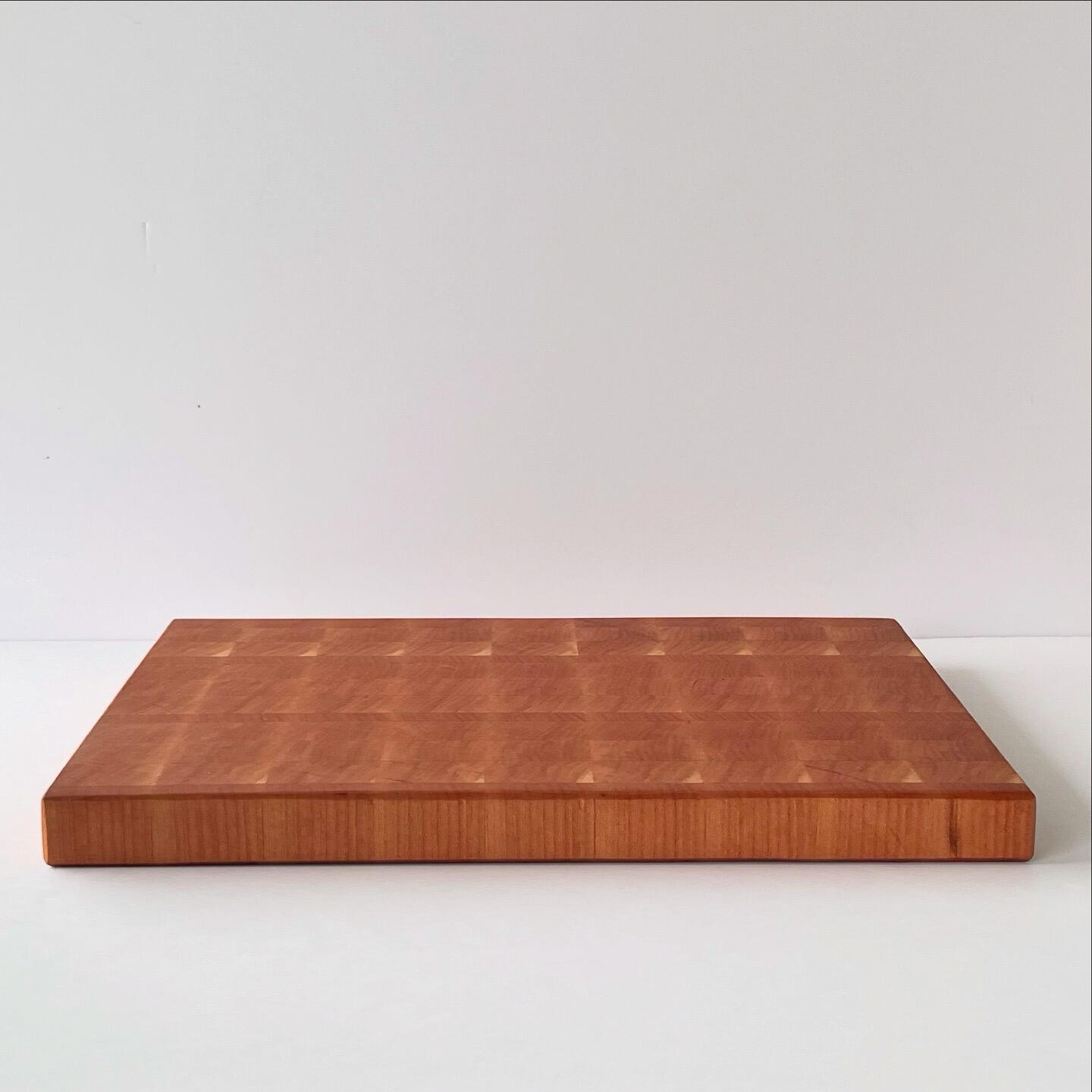 Image of a custom cutting board made with end-grain cherry wood.