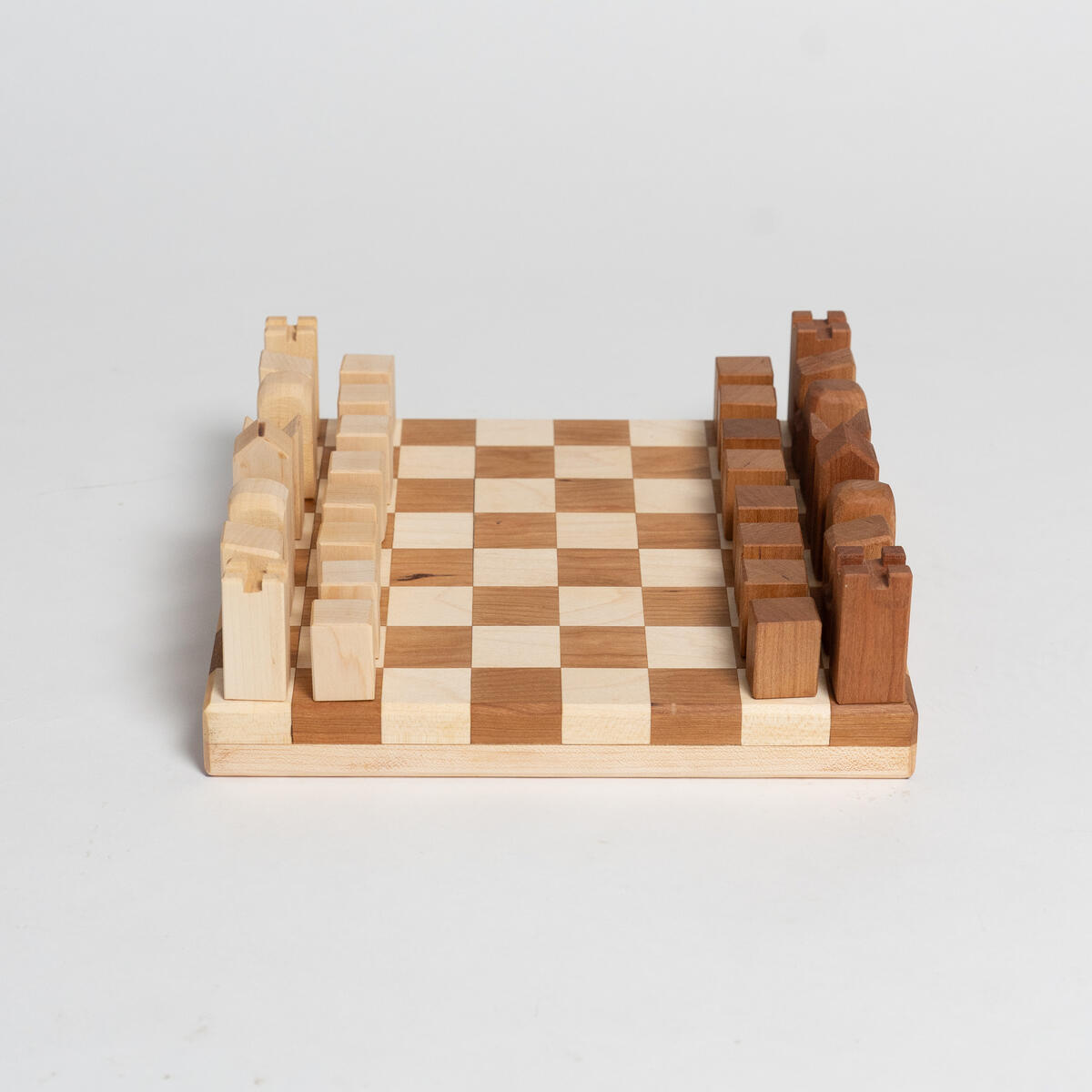A minimal, modern chess set made out of cherry and maple wood.